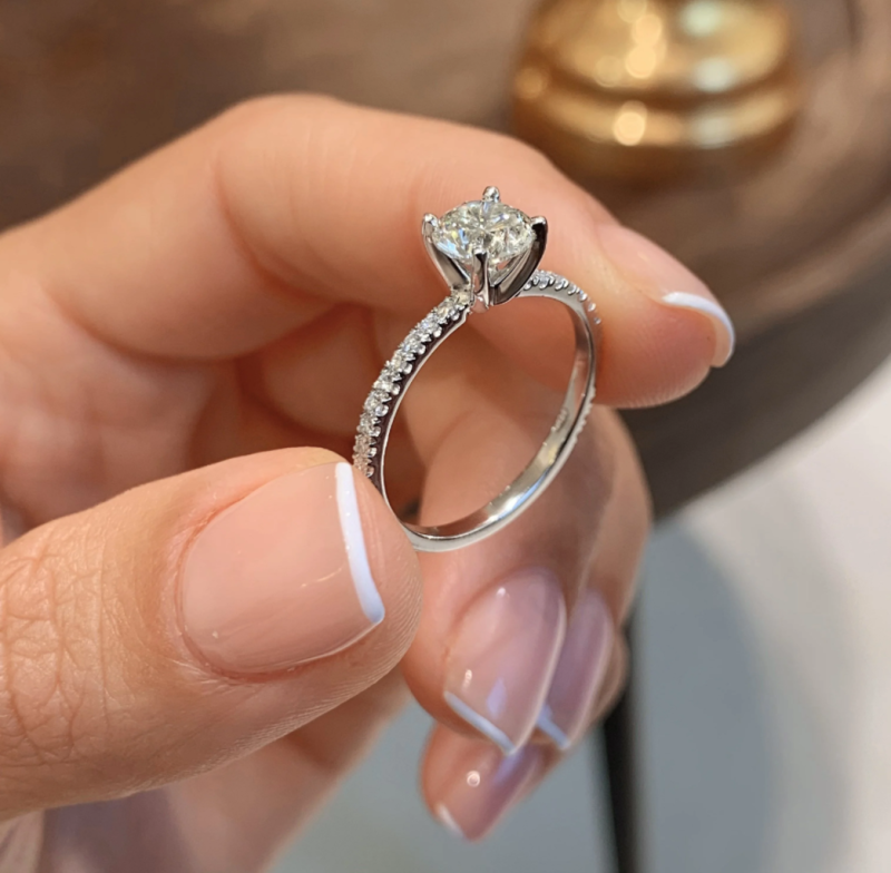 Elegant silver engagement ring with a solitaire stone and pave band design