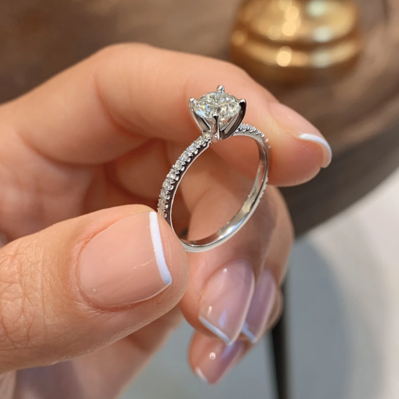 Elegant silver engagement ring with a solitaire stone and pave band design